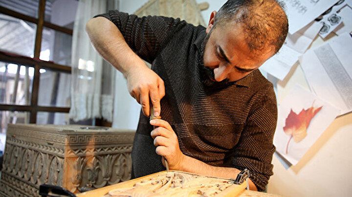 İğneyle kuyu kazar gibi ahşaba hayat veriyor