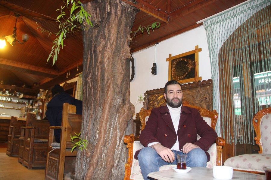 Kafenin ortasından yükselen ağaç dikkat çekiyor